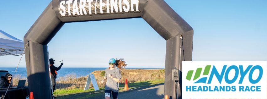 Runner crossing the finish line on the coastal trail in Fort Bragg at the 2023 Noyo Headlands Race.